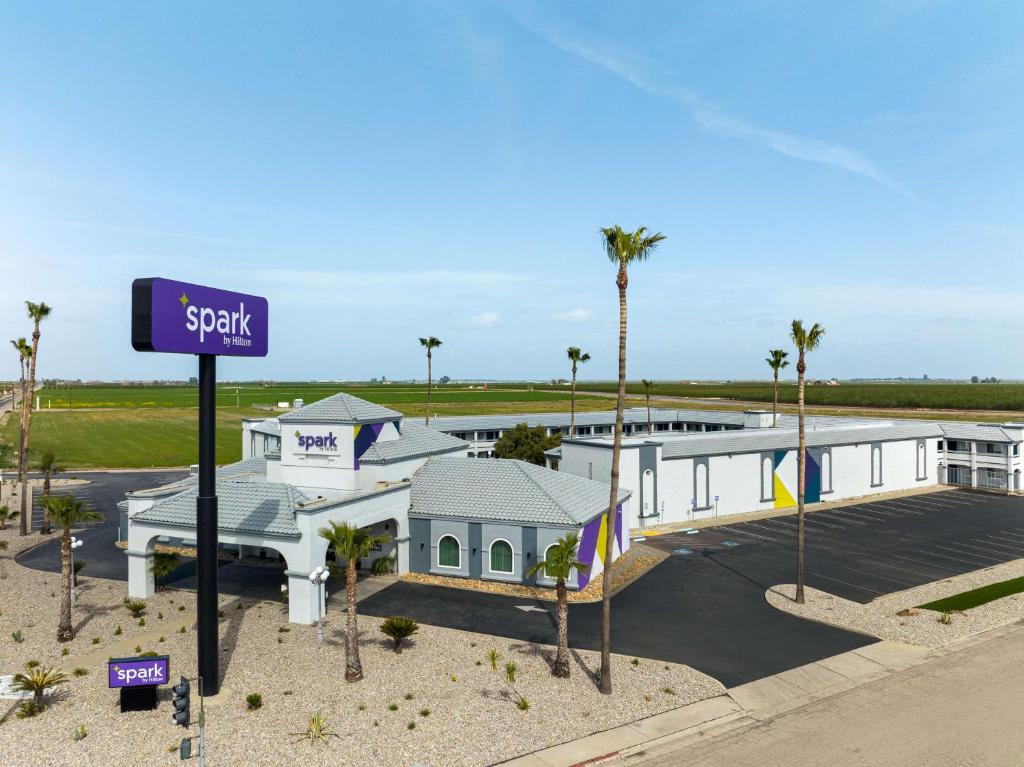 a large white building with a sign in front of it at Spark By Hilton Santa Nella in Santa Nella