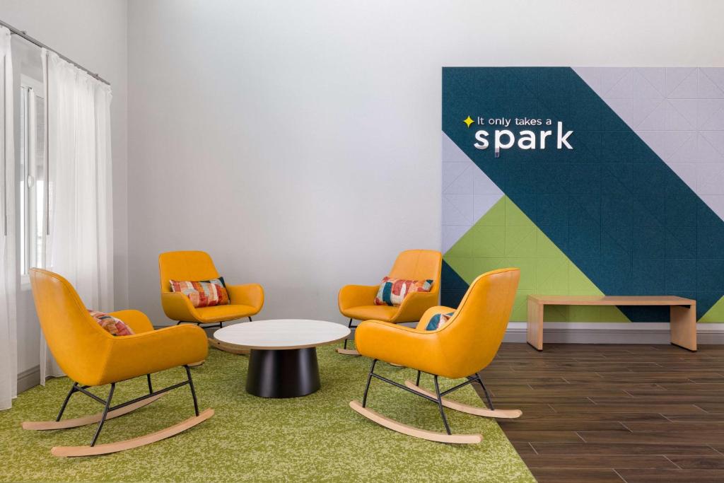 a waiting room with chairs and a table and a sign at Spark By Hilton Santa Nella in Santa Nella