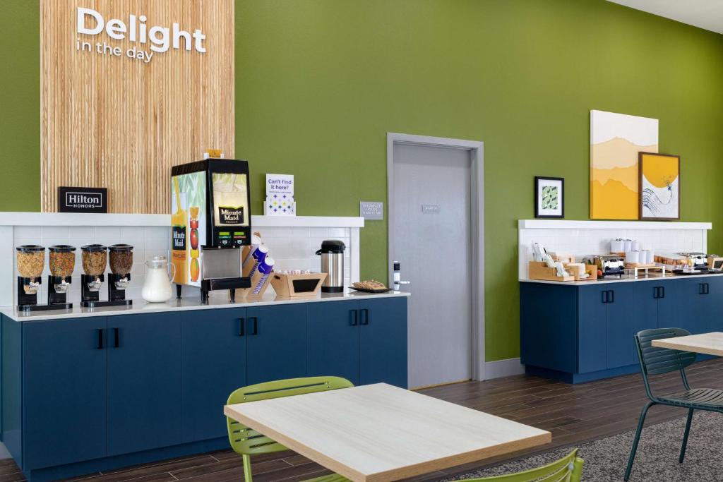 a kitchen with blue cabinets and a green wall at Spark By Hilton Santa Nella in Santa Nella