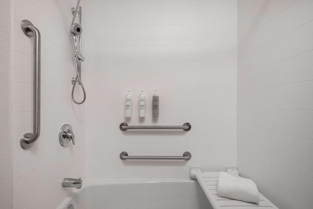 a white bathroom with a tub and a shower at Spark By Hilton Santa Nella in Santa Nella