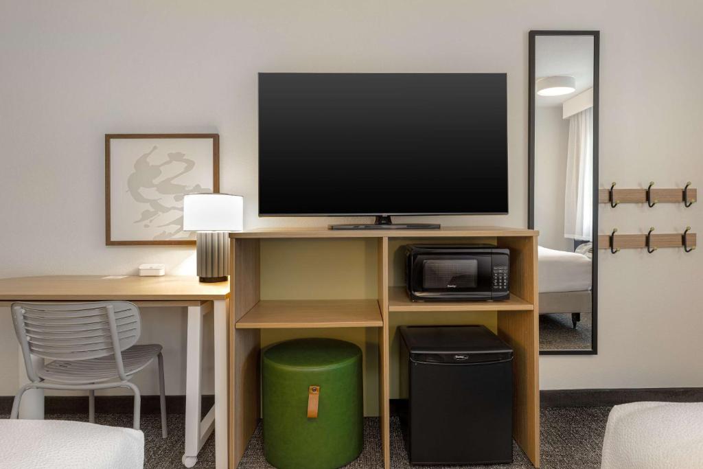 a room with a desk with a flat screen tv at Spark By Hilton Santa Nella in Santa Nella