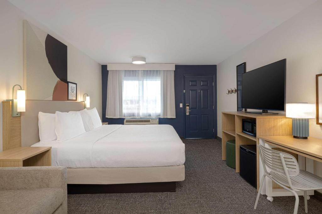 a hotel room with a bed and a television at Spark By Hilton Santa Nella in Santa Nella