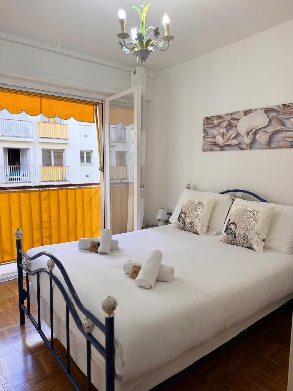 une chambre avec un grand lit blanc avec une fenêtre dans l'établissement La Residence du Casino, à Menton