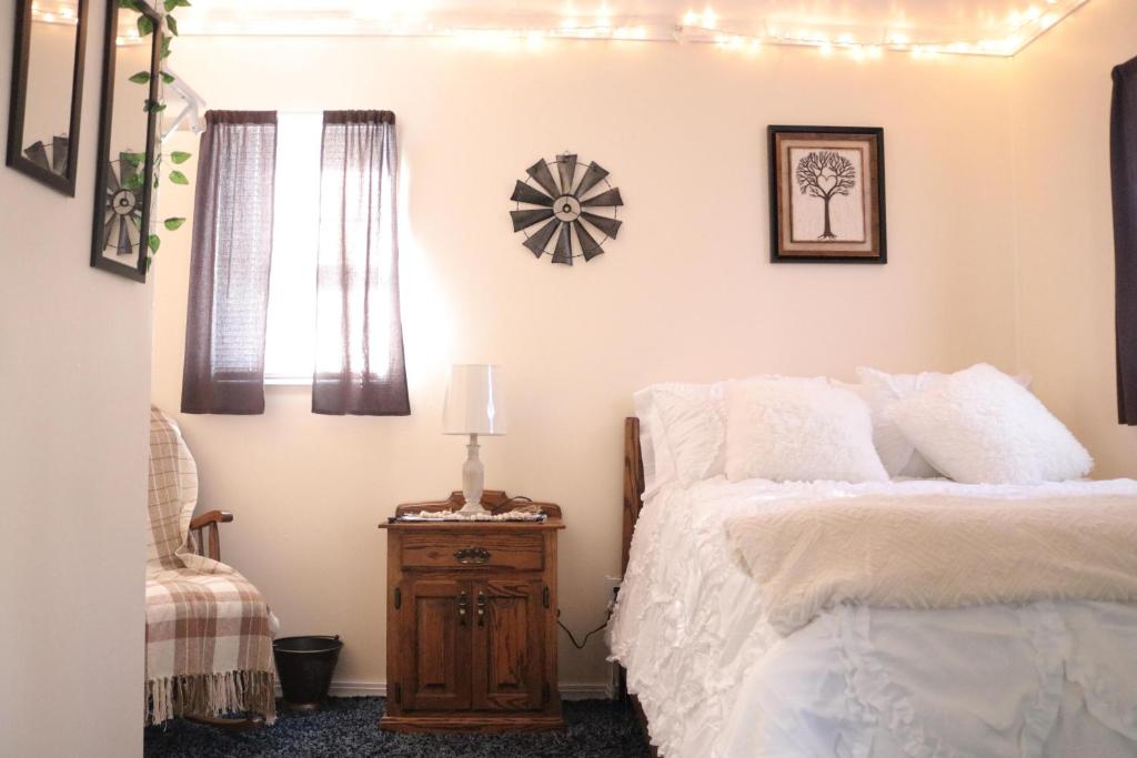 una camera con letto e comodino in legno di River Lane Cottage a Dunnville