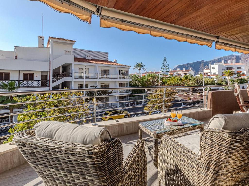 a balcony with wicker chairs and a table with a view at Santos Lerch Sol Apartment in Puerto de Santiago