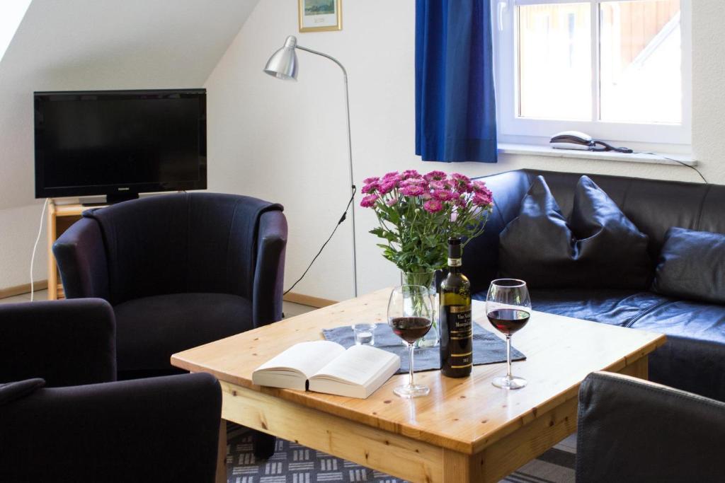 a living room with a table with wine glasses and flowers at Ferienwohnung Ferienhäuser am Brocken, 80 qm 3 Schlafzimmer in Ilsenburg