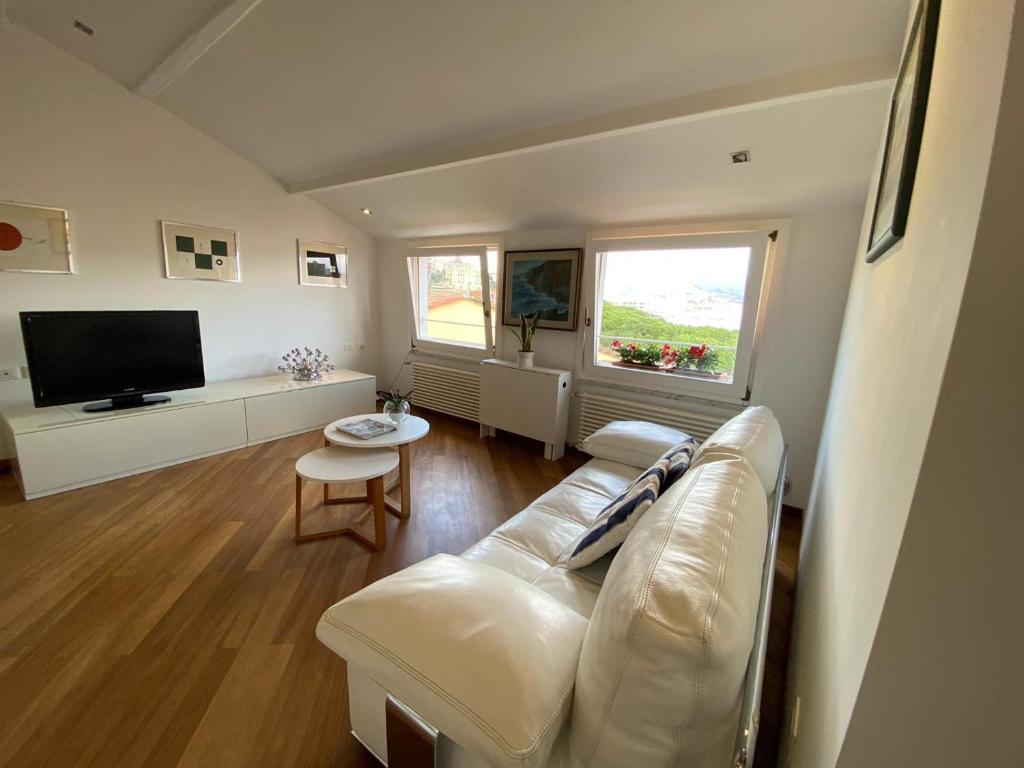 a living room with a white couch and a television at Il Nido d'amare in Fezzano