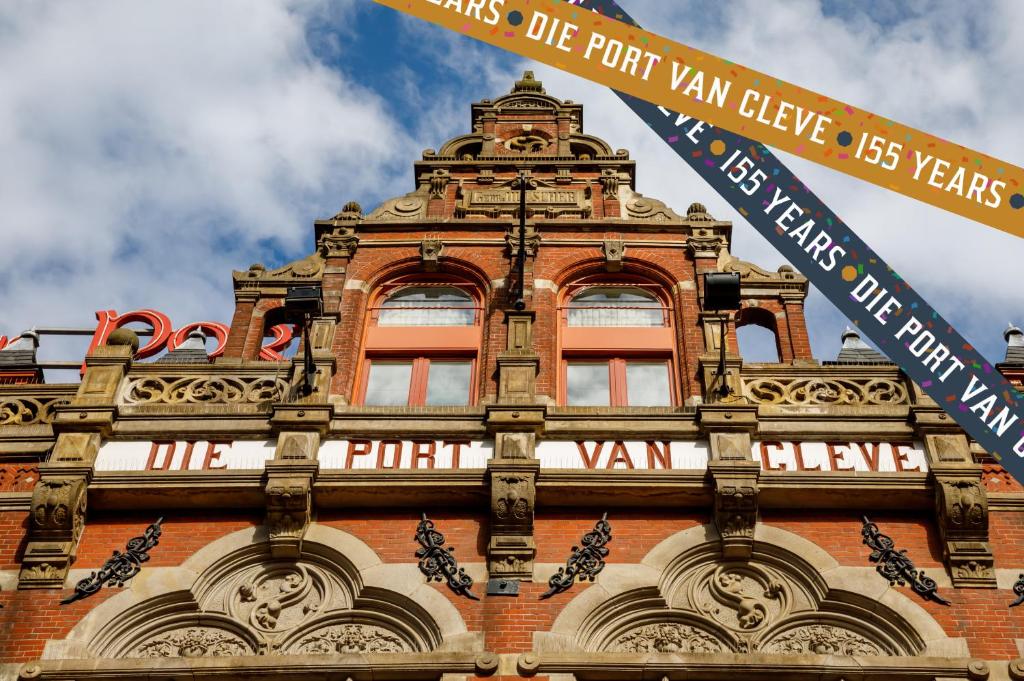 een hoog gebouw met borden aan de zijkant bij Hotel Die Port van Cleve in Amsterdam