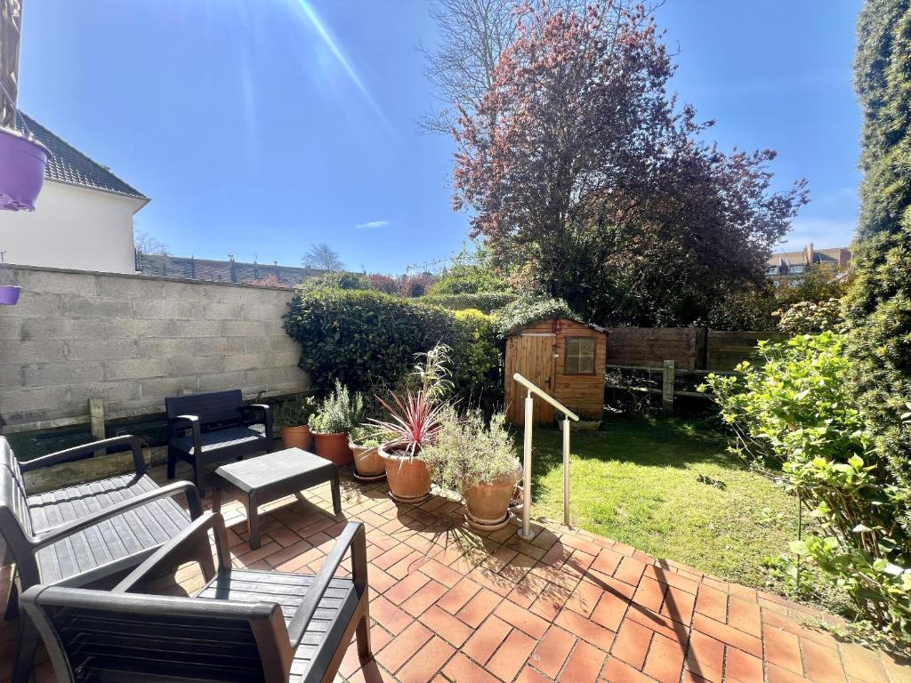 une terrasse avec bancs, plantes en pot et clôture dans l'établissement La Citadelle, à Calais