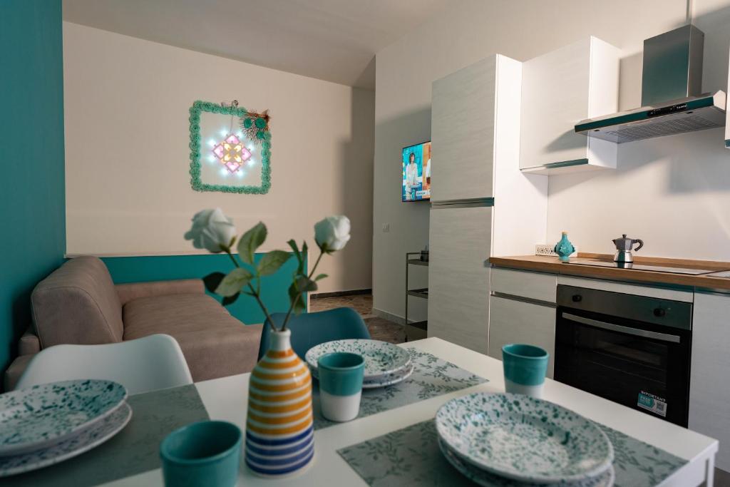 a kitchen and living room with a table with plates at Colè House in Bitetto