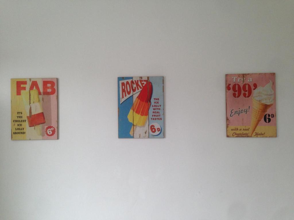 four signs hanging on a white wall at The Sandhaven in Swanage