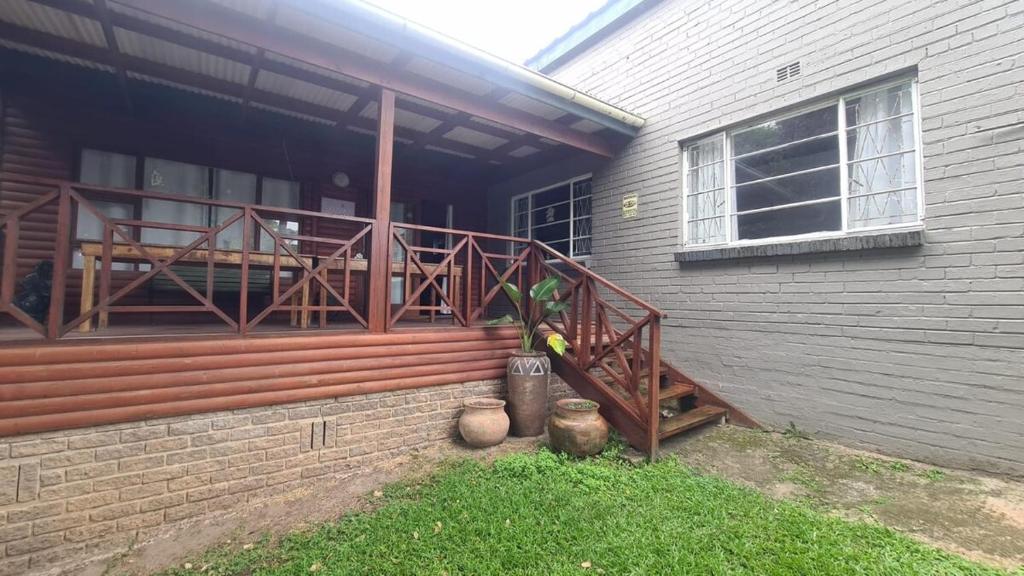 una veranda di una casa con terrazza in legno di Caboodle a Kenton-on-Sea