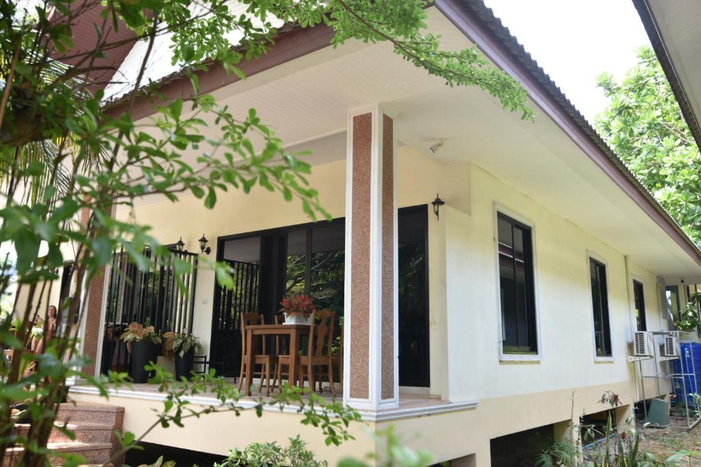 een huis met grote ramen en een veranda bij Baan Peaceful Villa 2, Ao Nang in Krabi town