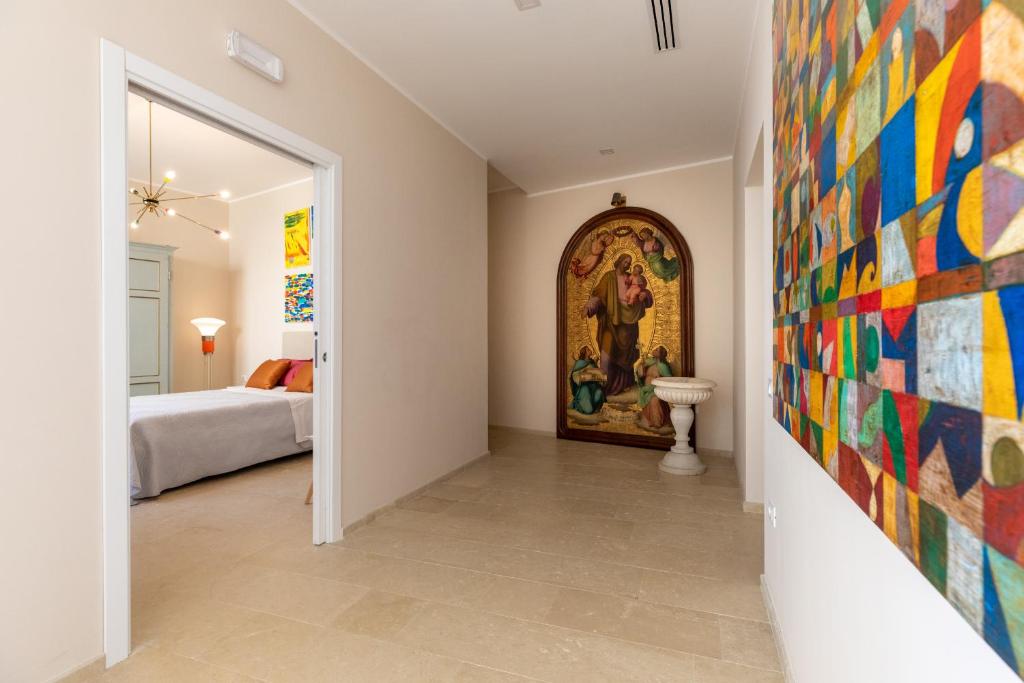 a hallway with a painting on the wall and a bedroom at Aurispa 143 con piscina Noto centro in Noto
