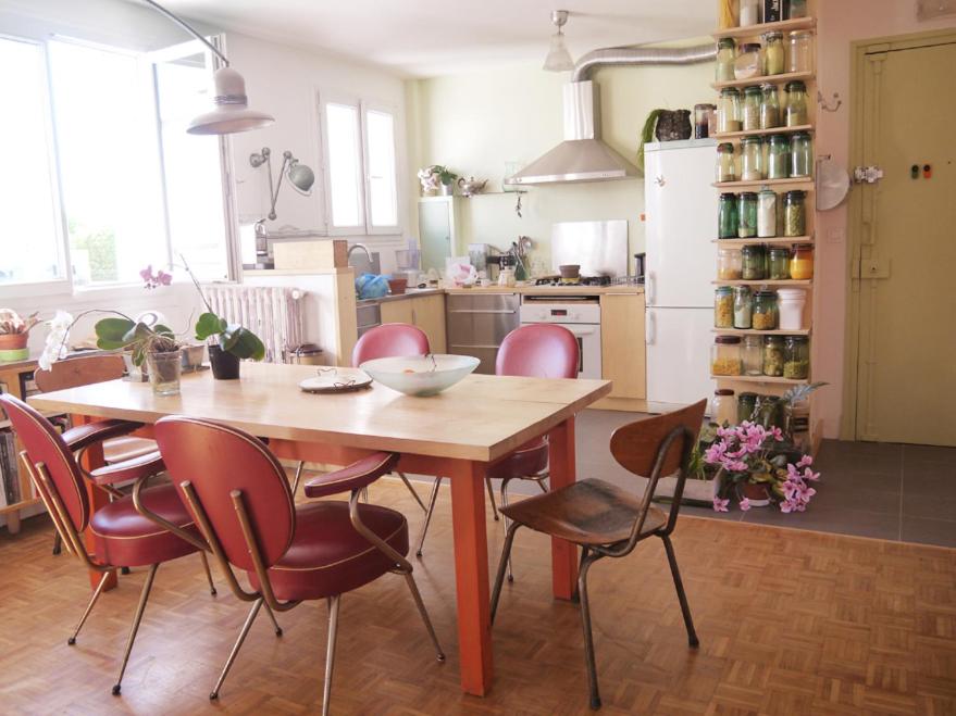 une cuisine avec une table et des chaises dans une pièce dans l'établissement Lumineux, calme, charme villageois à 2mn du métro parisien, à Malakoff