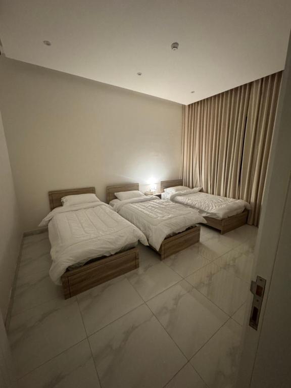 two twin beds in a room with at Hotel Apartment - 4 - LAvner Al hussma in Quai