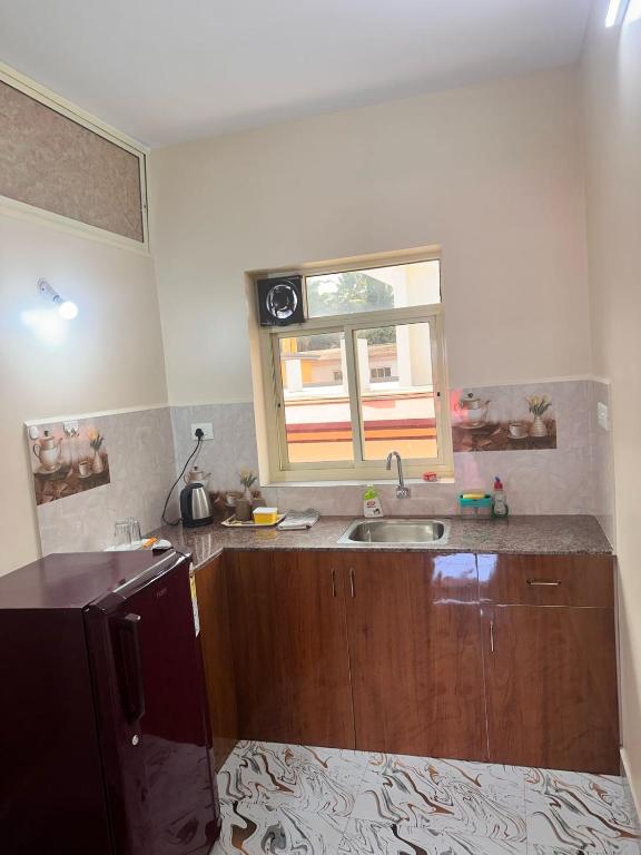 a kitchen with a sink and a window at James Guesthouse in Bogmalo