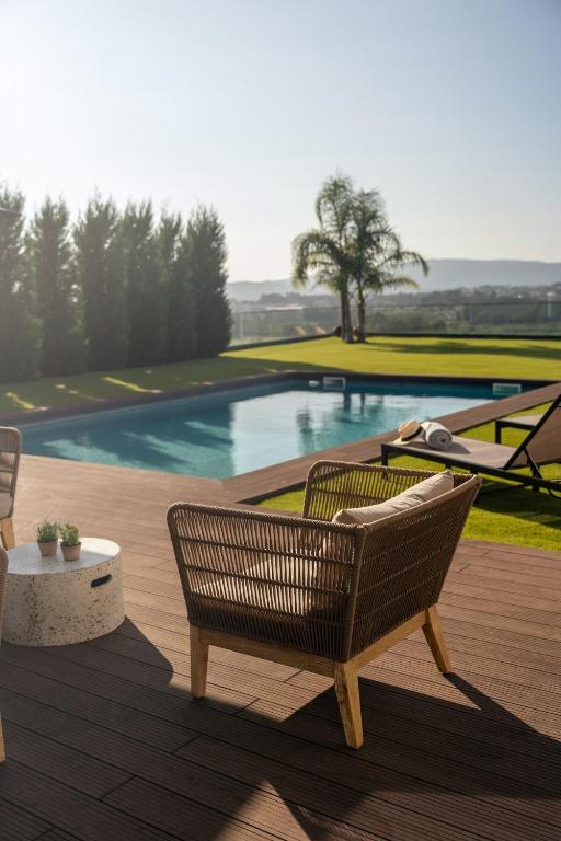 a patio with two chairs and a swimming pool at Vietnam House in Barcelos