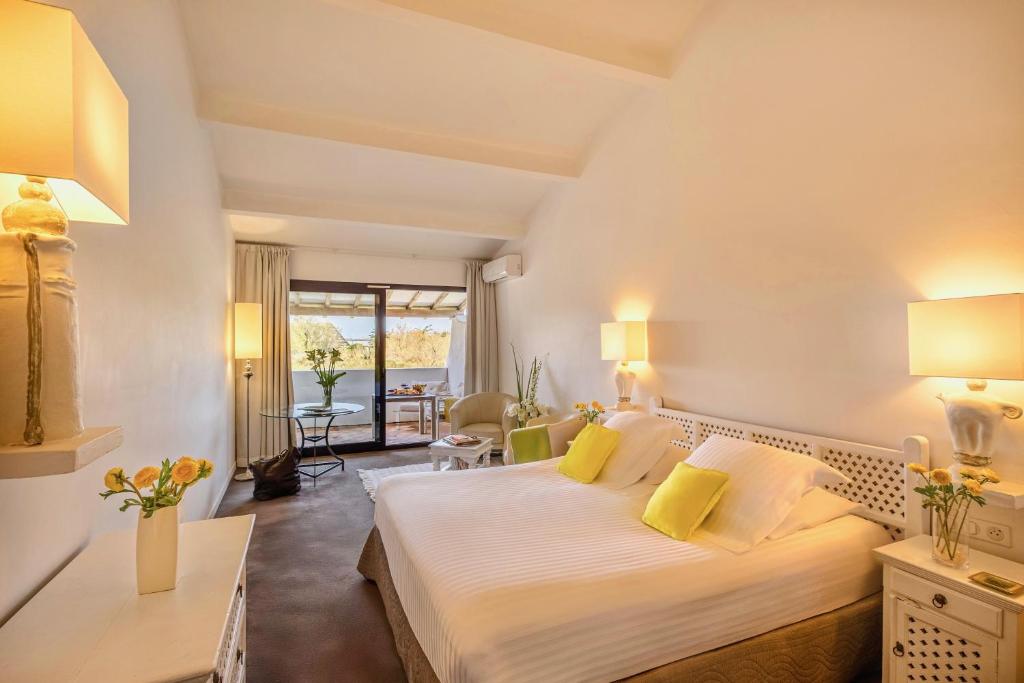 a hotel room with a large bed with yellow pillows at Mangio Fango Hotel et Spa in Saintes-Maries-de-la-Mer