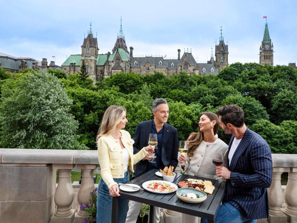 a group of people standing around a table with food and wine at Fairmont Chateau Laurier in Ottawa