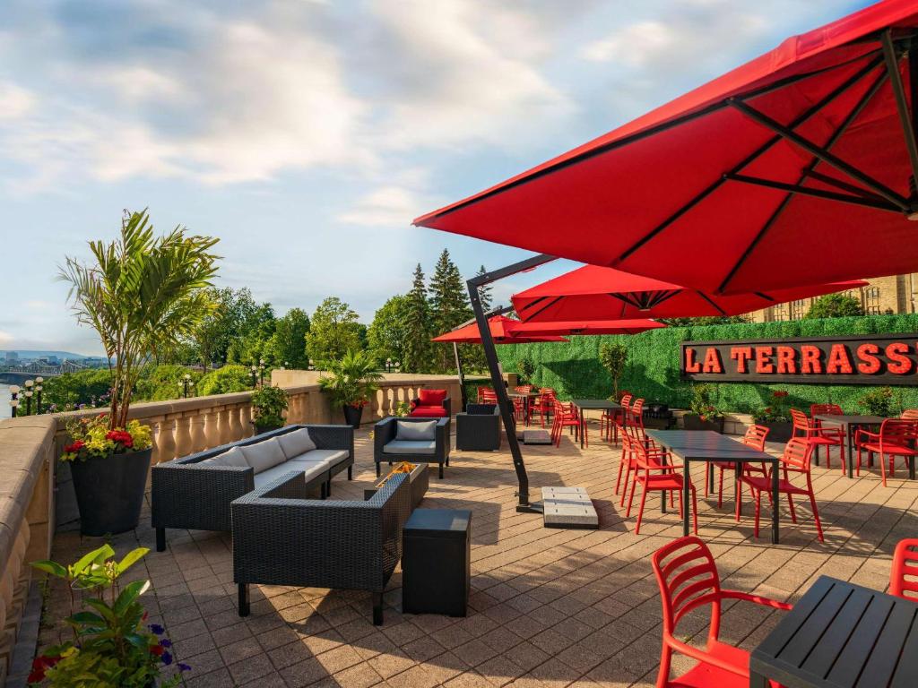 a patio with tables and chairs and a red umbrella at Fairmont Chateau Laurier in Ottawa