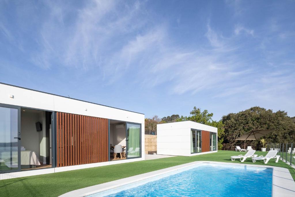 una casa con piscina nel cortile di Bungalow 1 con piscina en la playa a A Pobra do Caramiñal