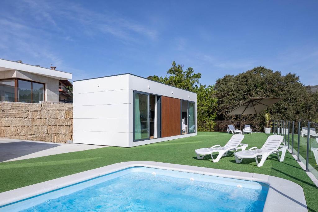 un cortile con piscina e una casa di Bungalow 2 con piscina en la playa a A Pobra do Caramiñal