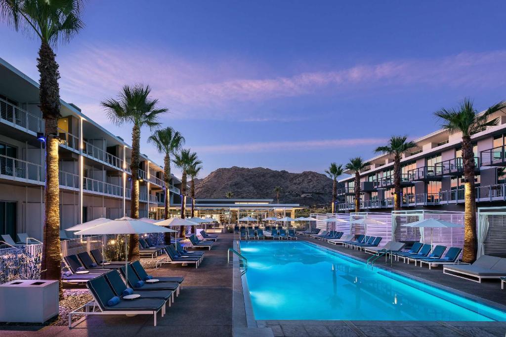 a resort swimming pool with chairs and palm trees at Mountain Shadows Resort Scottsdale in Scottsdale