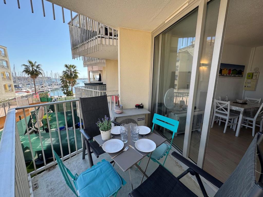 un patio avec une table et des chaises sur un balcon dans l'établissement Appartement - Cap d'Agde, au Cap d'Agde