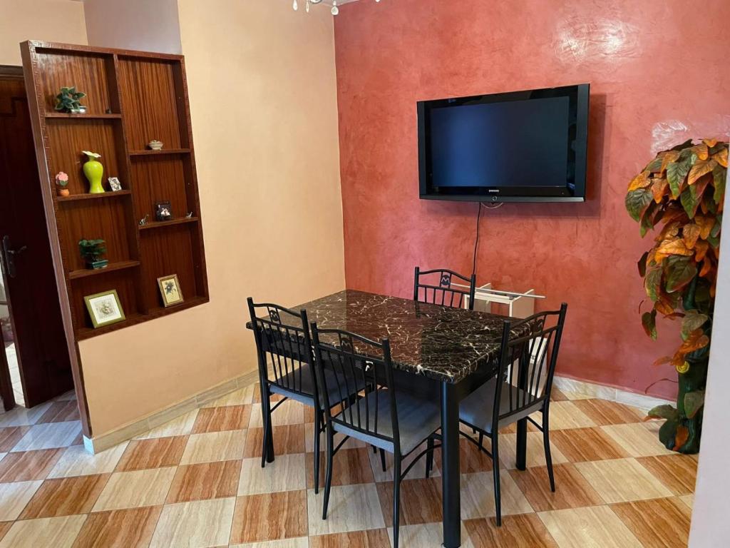 Un comedor con una mesa y un televisor de pantalla plana. en Dar dyafa, en Casablanca