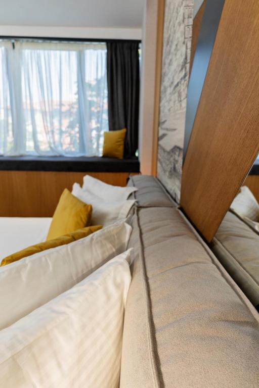 a bed with pillows on it in a room at MM Boutique Hotel in Burgas
