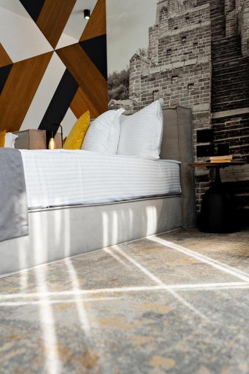 a bedroom with a bed and a brick wall at MM Boutique Hotel in Burgas