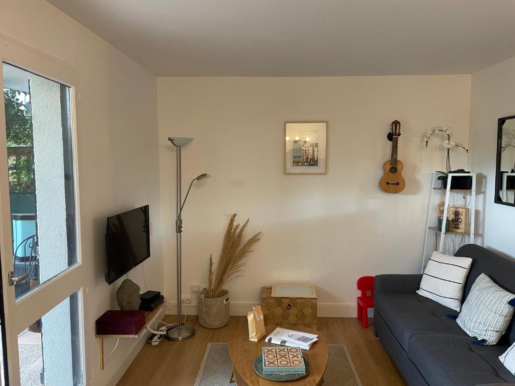 un salon avec un canapé bleu et une table dans l'établissement Casa Romantica, à Cabourg