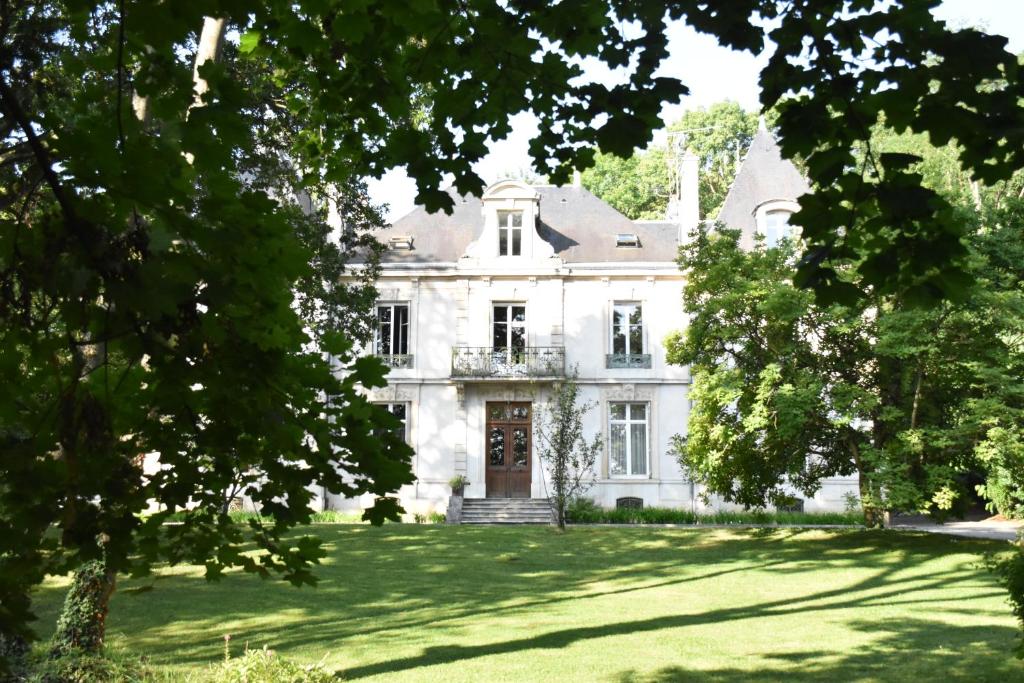 une grande maison blanche avec une grande cour dans l'établissement L'appartement du parc, à Nancy