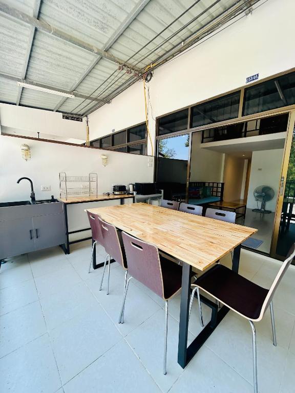 a large room with a wooden table and chairs at Island House Rentals 46 in Ko Samed