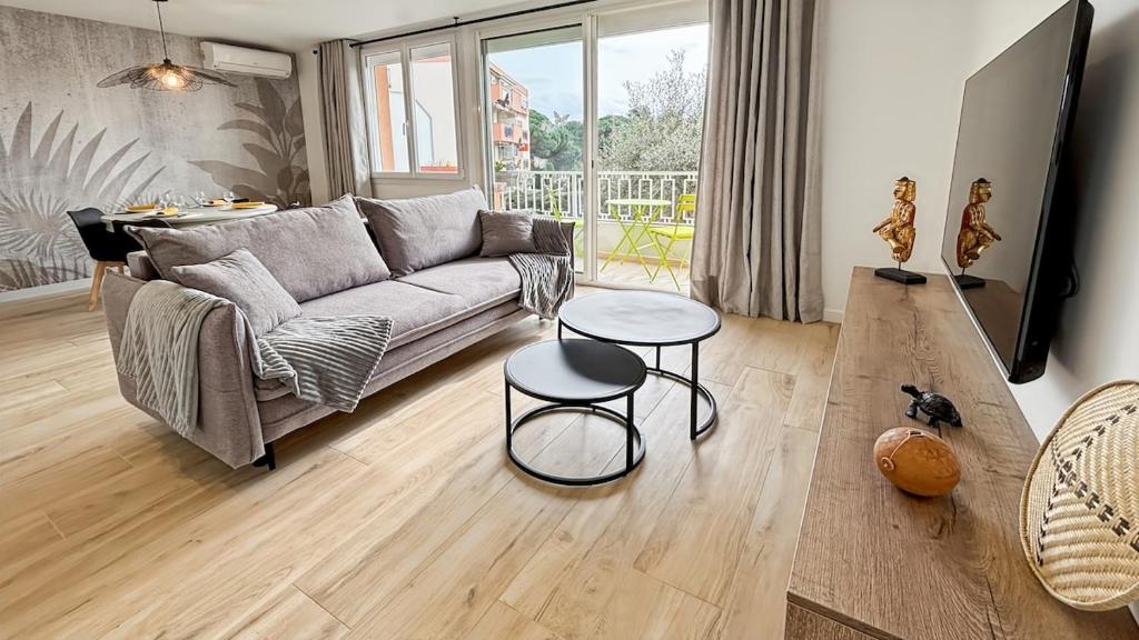 a living room with a couch and a table at Appartement a quelques minutes à pieds des plages in Fréjus