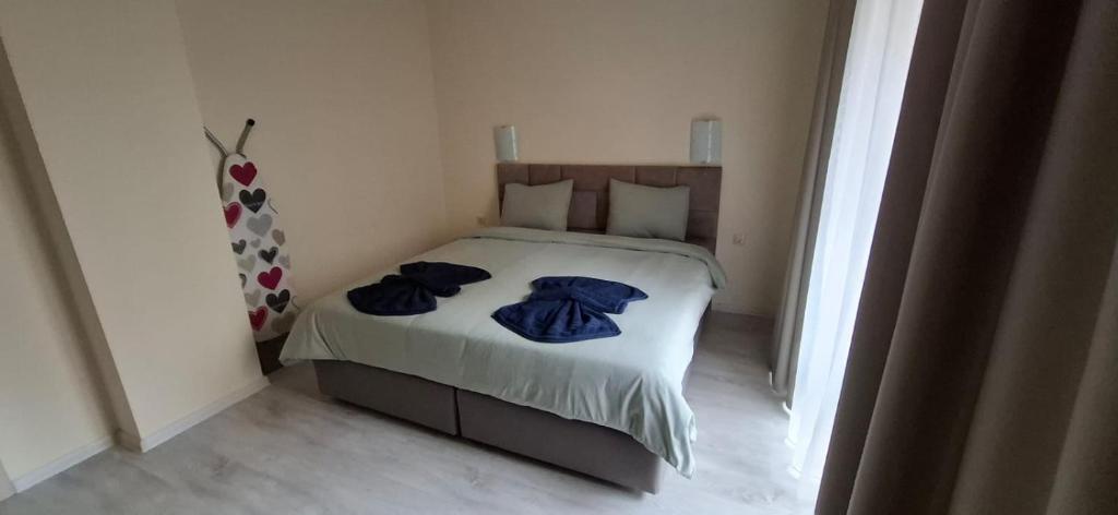 une chambre avec un lit avec des vêtements bleus dessus dans l'établissement Star Dreams P2, à Sveti Vlas