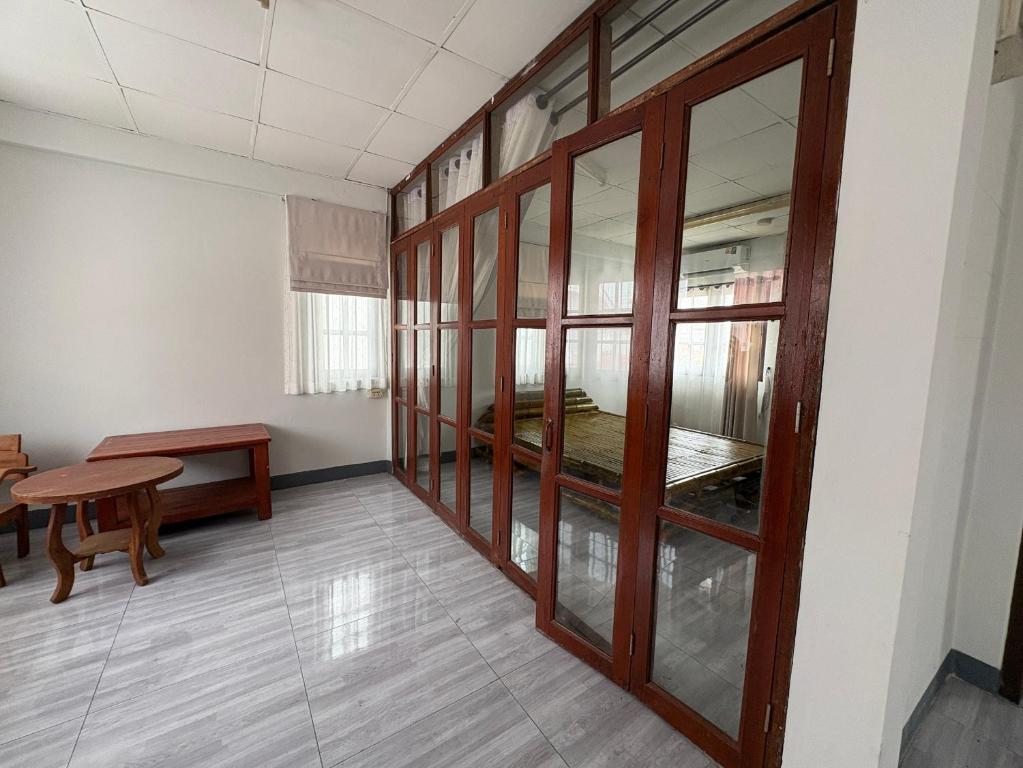 a room with a room with a bed and a table at MeeboonHome in San Kamphaeng