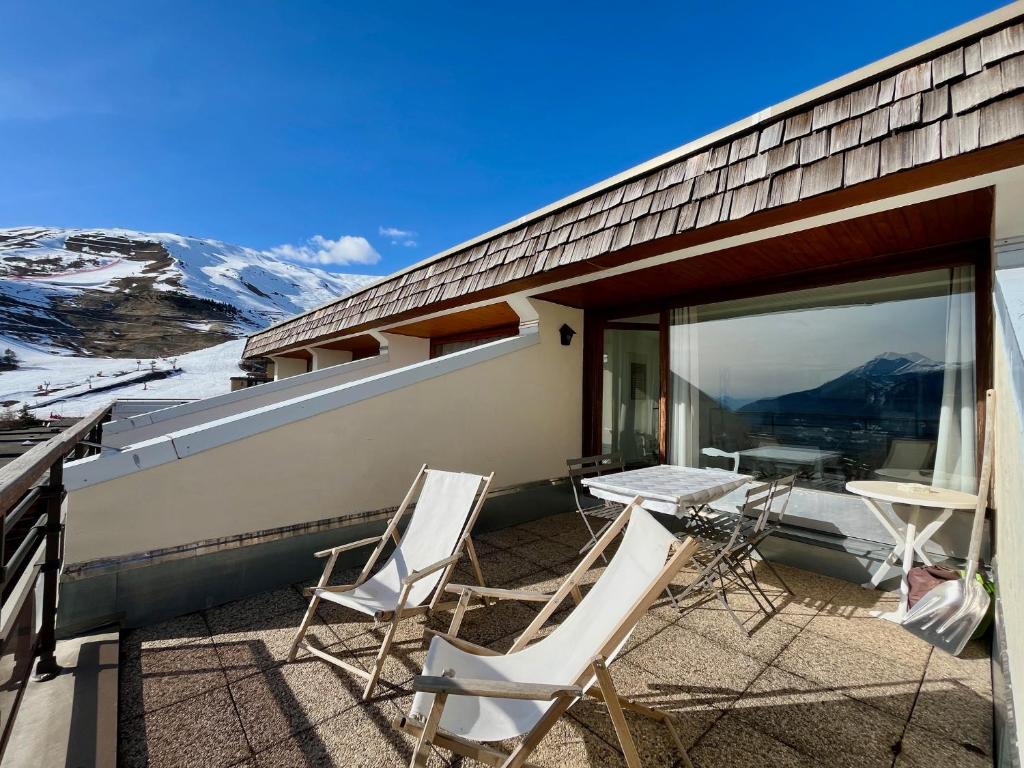 - un balcon avec deux chaises et une table dans l'établissement Le Bellevue T3 - Orcières Merlette, à Orcières
