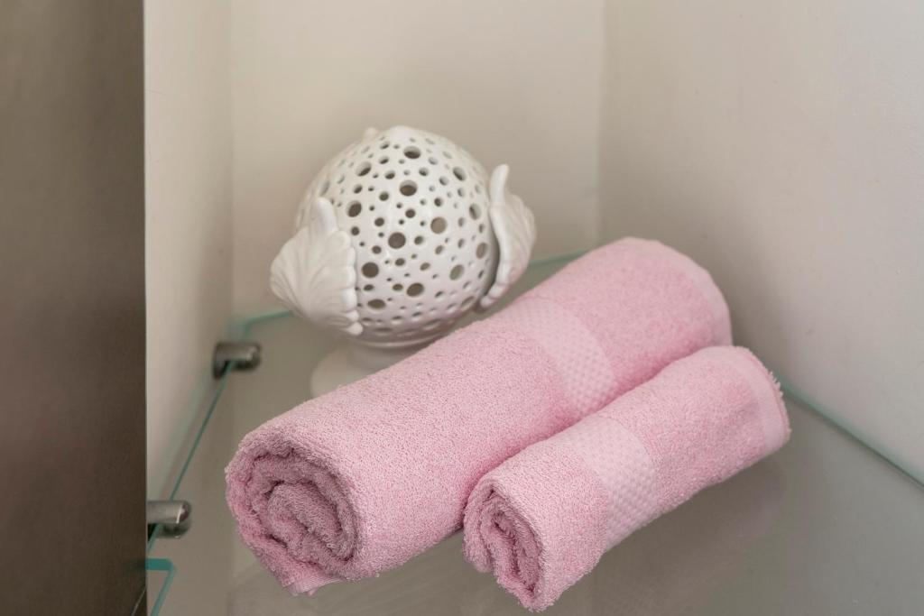 a pink towel on a shelf in a bathroom at Martini Matera 2-luxury apartment in Matera