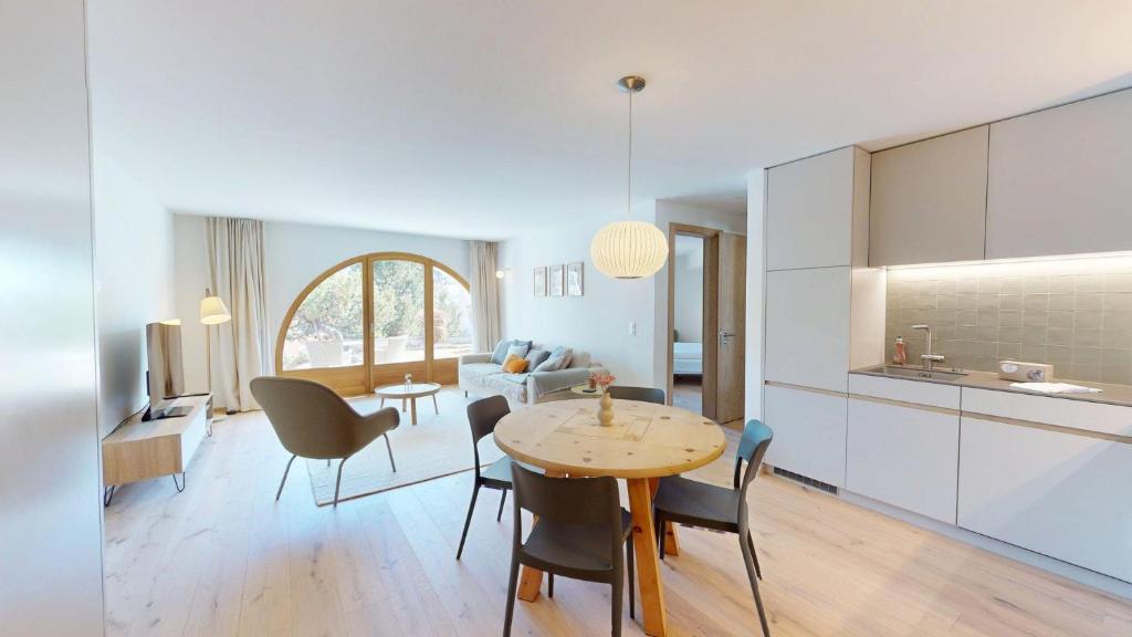 a kitchen and living room with a table and chairs at Leonard in Celerina