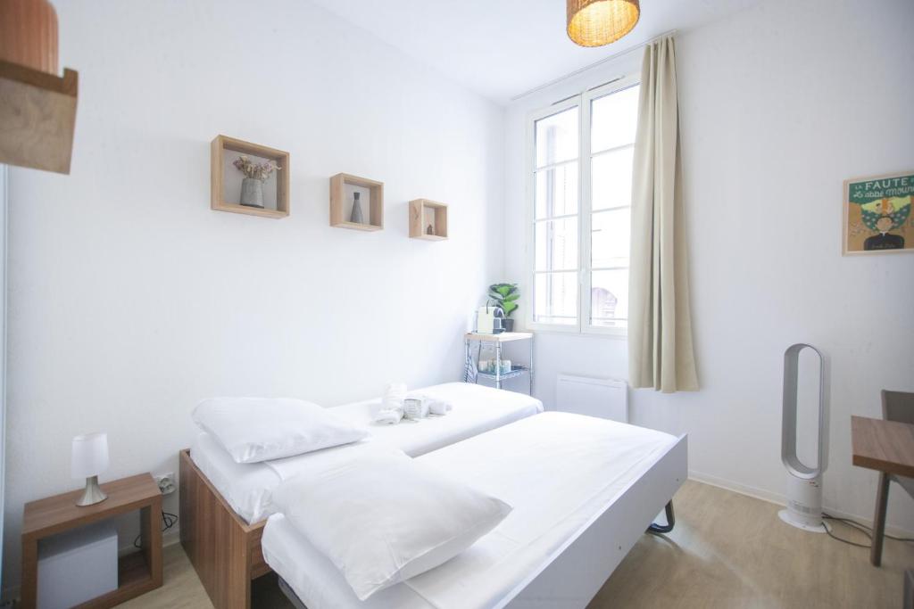 une chambre blanche avec un lit et une fenêtre dans l'établissement SENAC - Havre citadin, La Canebière, à Marseille
