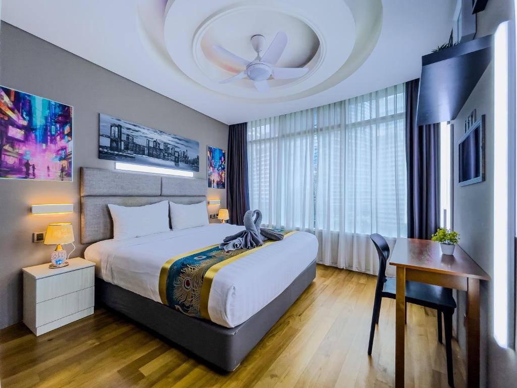 a bedroom with a bed and a table and a ceiling at Vortex Suites Klcc By VIP SUITES in Kuala Lumpur