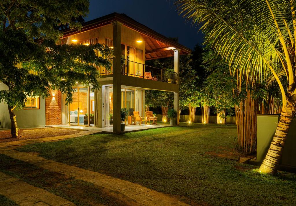 una casa con una palmera delante en Villa Rumassala Luxury Chalets Unawatuna, en Unawatuna