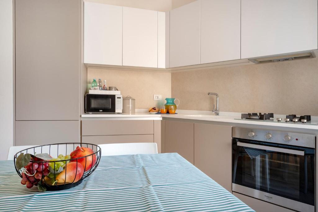a kitchen with a bowl of fruit on a table at Martini Matera 2-luxury apartment in Matera
