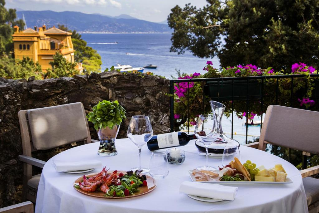a table with a plate of food and wine glasses at Hotel Piccolo Portofino in Portofino