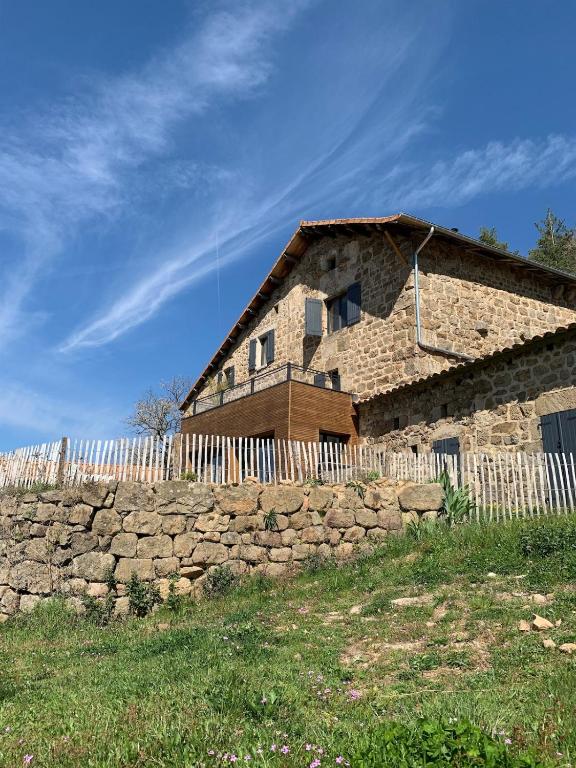 une ancienne maison en pierre avec un mur en pierre dans l'établissement Les sources d avenas, à Saint-Jean-Roure