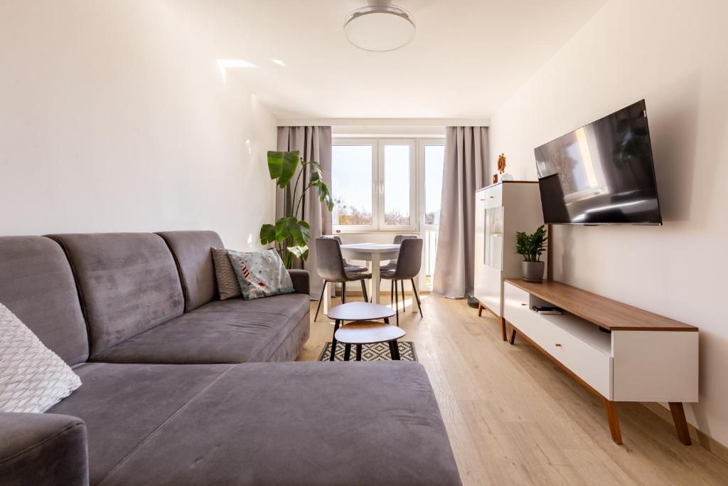 a living room with a couch and a table at Wejhera Beige Chic Apartment by BookingHost in Gdańsk