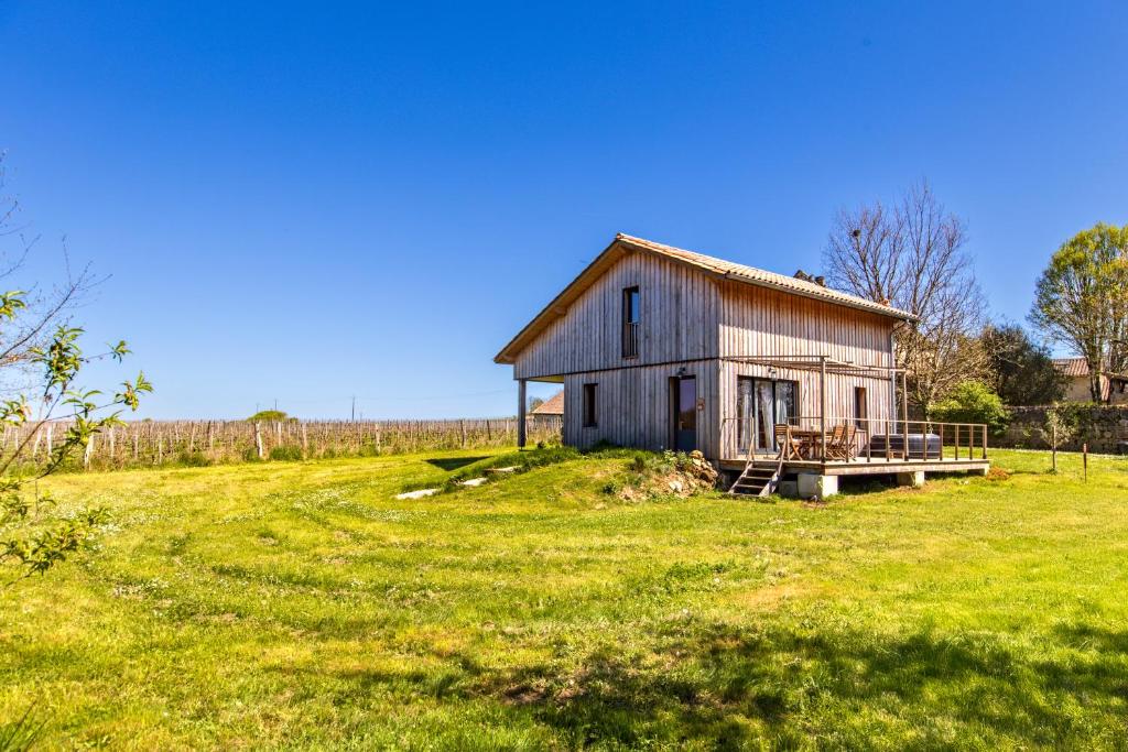 une ancienne grange assise sur un champ herbeux dans l'établissement Lodge evasion fleurie st Emilion, à Guillac