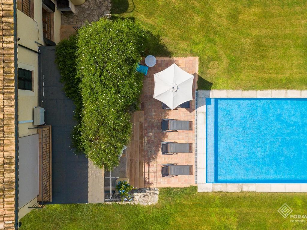 an overhead view of a pool with a white umbrella at Son Senyor in Sa Pobla